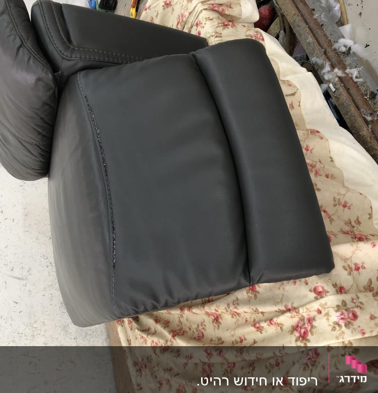 כרית עור שחורה על כיסוי פרחוני